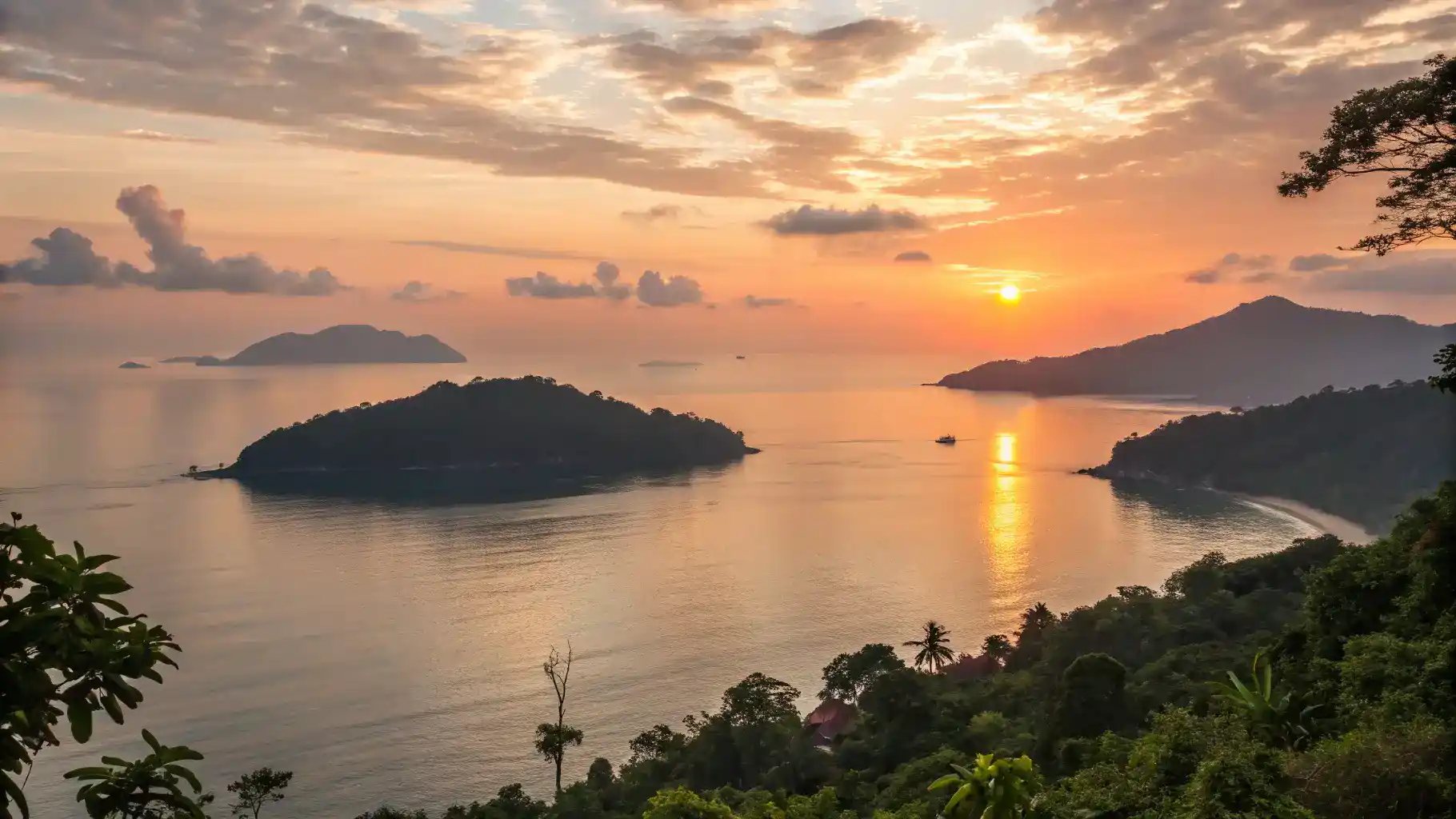 Serene sunset view over the Perhentian Islands with warm colors reflecting on the water.