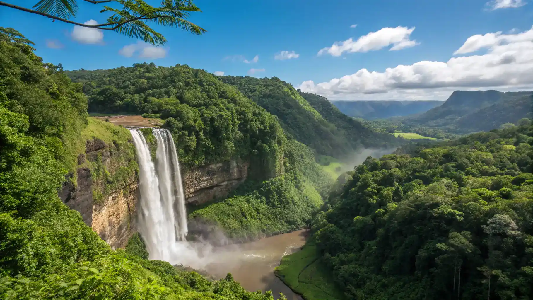 A stunning waterfall in Puerto Rico surrounded by lush greenery and a clear blue sky.