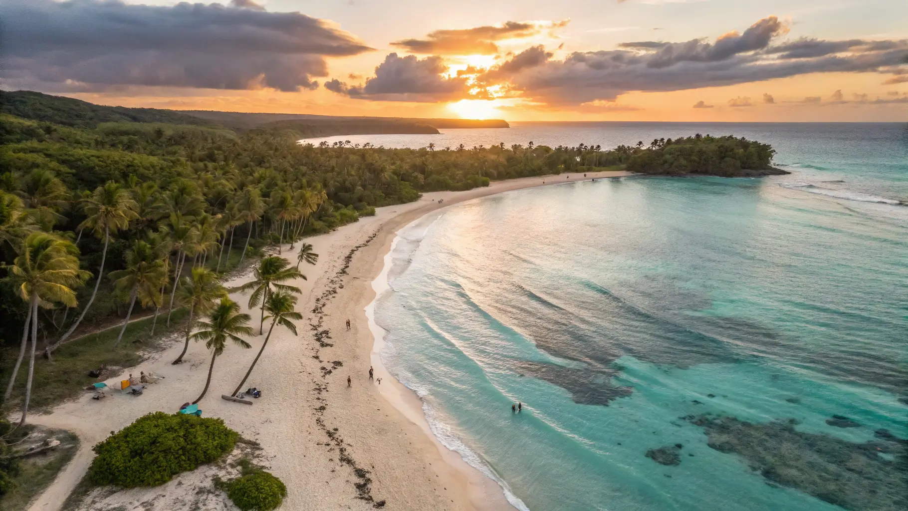 A stunning sunset view of a Puerto Rico beach with white sand and turquoise waters, surrounded by palm trees.